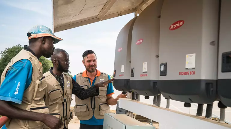 Männer vor Wechselrichter in Mali