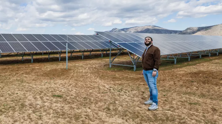 system owner in front of the modules in Greece